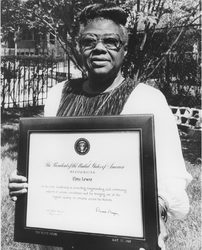 Elma Lewis standing with award from President Ronald Reagan