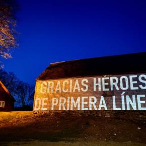 Wall with a digital projection that reads, "Gracias Heroes de Primera Linea"