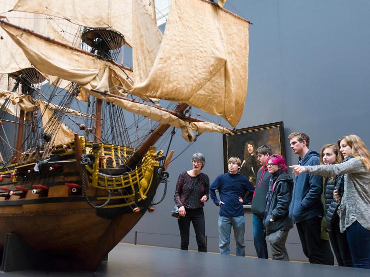 Students admiring a ship on display in a museum