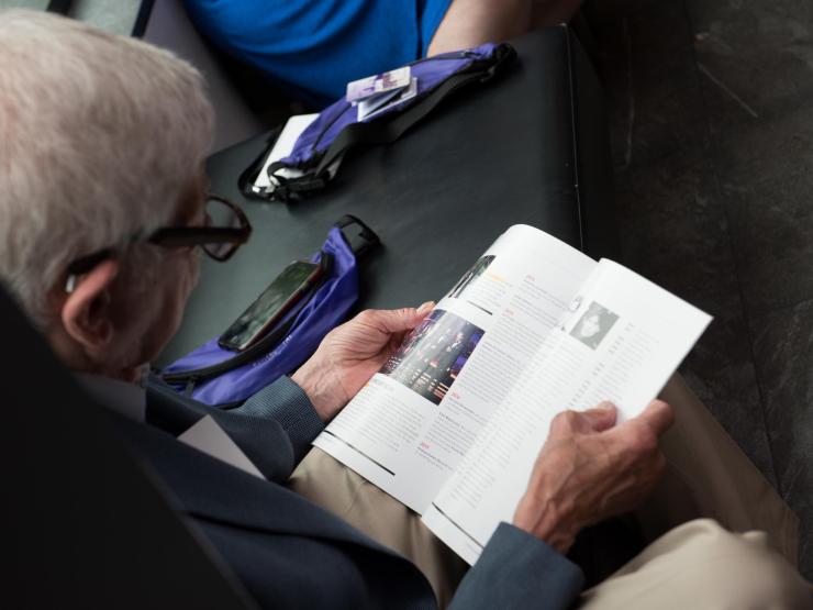 Alumnus looking through a copy of Expression magazine