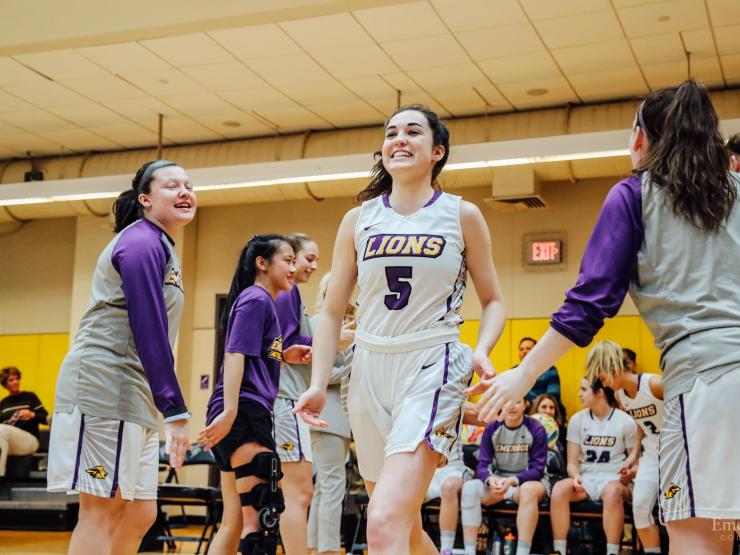 Basketball player being cheered by teammates