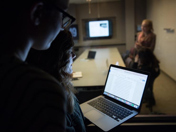 marketing communication students look into focus room through two-way mirror
