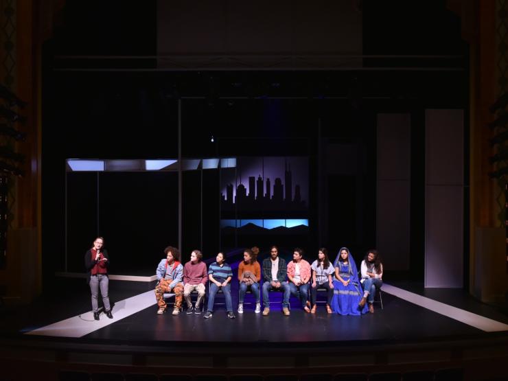 students sitting in a line on stage