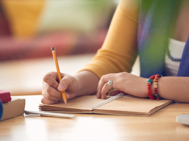 Close up shot of a student writing in a notebook