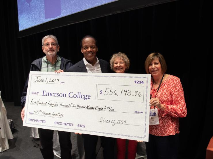 Photo of President Pelton standing with alumni, holding an oversized novelty check made out to Emerson College, in the amount of $556,198.36. It is contributed by the Class of 1969, a 50th Reunion class gift.