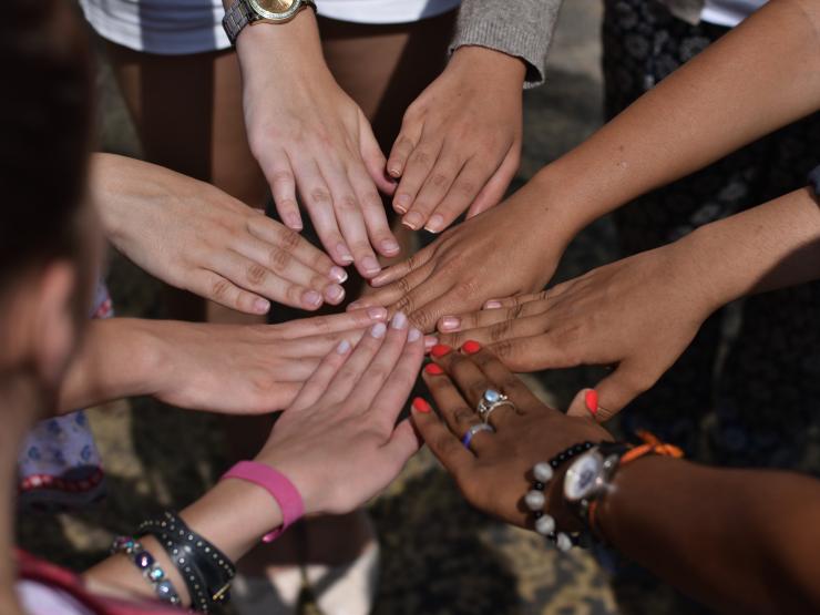 Group Of People Putting Their Hands Together In Circle