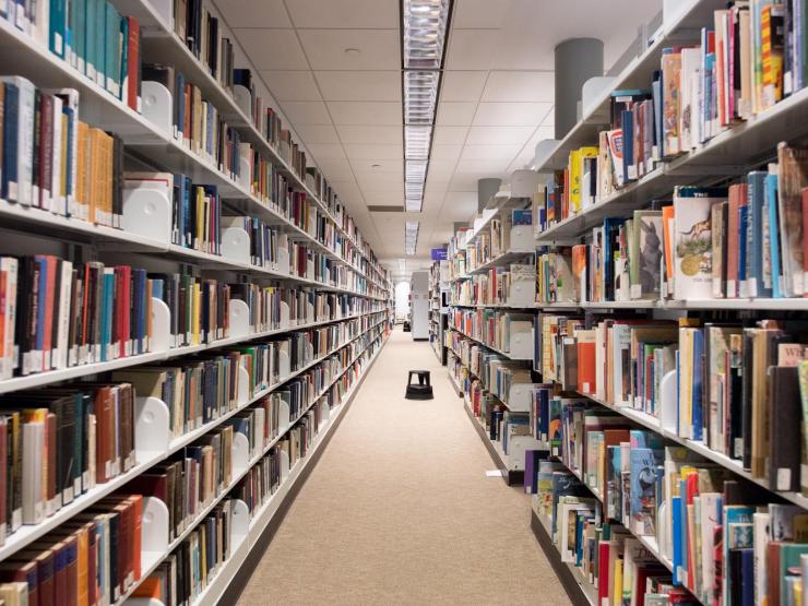 A clear aisle in the Iwasaki Library, lined with stacked bookshelves
