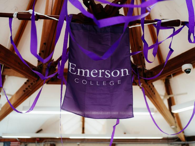 Decorations at Commencement featuring purple streamers and the Emerson College logo