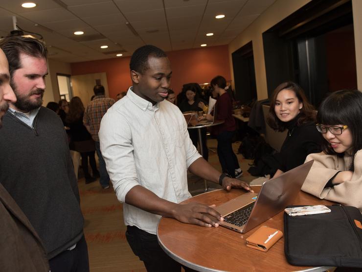 group of graduate students talk at table