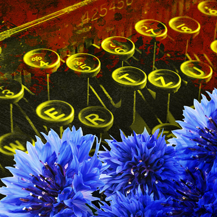 A closeup of typewriter keys with a yellow filter and blue flowers in the corner