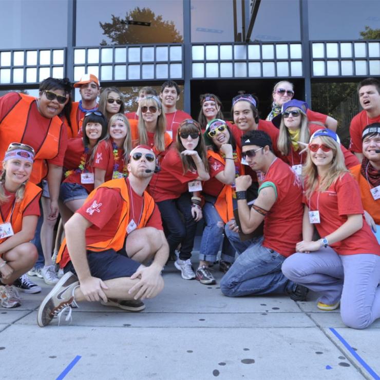 A group of Emerson students posing in red shirts and orange vests