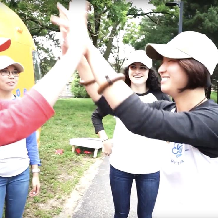 Two women high-fiving outside