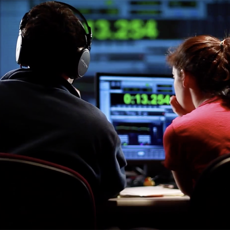 Two students sitting in a broadcast control room