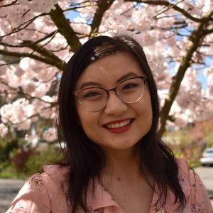 Michelle Li smiling in front of cherry blossom trees
