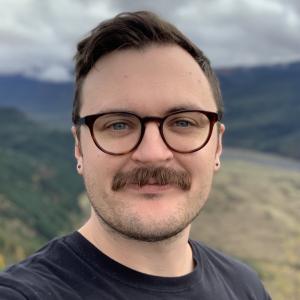Headshot of Sean Mullady in front of a mountain range