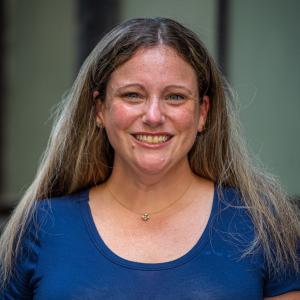 a photo of Elizabeth Davis smiling outside the Union Bank Building wearing a blue top