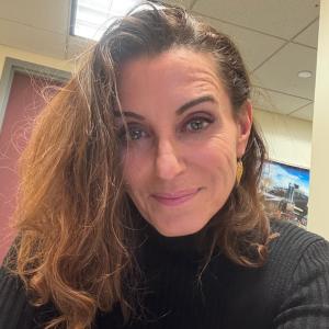 photo of Israela Brill-Cass, a white woman with brown hair wearing a black turtleneck
