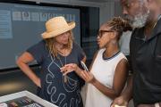 media design student speaking with professor at gallery event