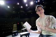 A student rehearses a play on stage