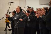 Black nativity singers in front of a microphone