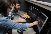 Students working together at computer in digital post-production suite