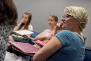 Faculty members sitting down and listening to a speaker