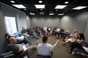 Room of older students and faculty members talking in a circle