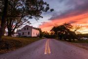 House at the top of a road with sunset in the background