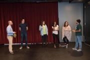 6 people standing in a large room talking
