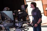 Student operating camera in television production studio