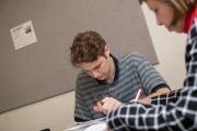 Students at table reviewing writing with pens