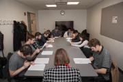 Students around table reading scripts