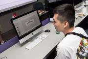 Close-up of student working on desk computer