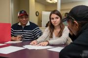 Students looking over paperwork with faculty member