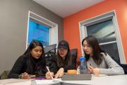 Three students working together on a worksheet