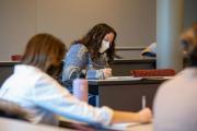 Students wearing face masks and taking notes during the Innovation for Impact course