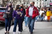 people wearing "Emerson" hoodie walking on campus