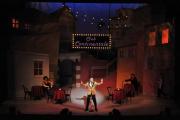 Student performing solo in the spotlight on stage