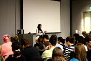 A woman presenting to an audience of students