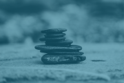 A photo of flat stones stacked on one another with a light blue overlay