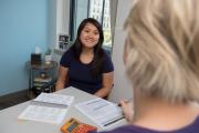 Student talking with advisor off-camera. A set of papers are on the table between them.