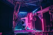 Person posing for performance in decorated wireframe cube