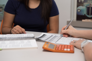 Student with faculty member who is writing and using calculator