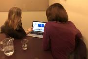 Two women sitting at a computer, performing a speech exercise