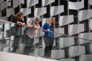 three students at Emerson Los Angeles facility standing and talking on balcony