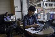 Student in digital content management class working on laptop in a cafe