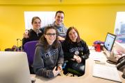 Undergraduate students smiling at the visitor's desk