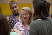 A group of undergraduate students standing and smiling at each other