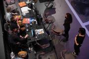 Overhead view of three students sitting at a table full of tech equipment and books