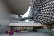 Two sharply contrasting grey buildings connected by two tunnels create a walkway